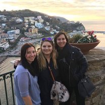 The Rome Center campus Three girls standing in front of the Amalfi Coast at sunset.
