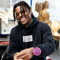 Summer Study Abroad Student laughing while working on a garment.